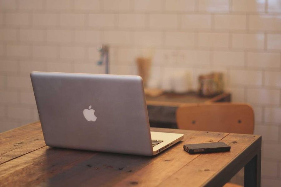 Laptop on wooden desk in cafe | Techyza WordPress Development Agency