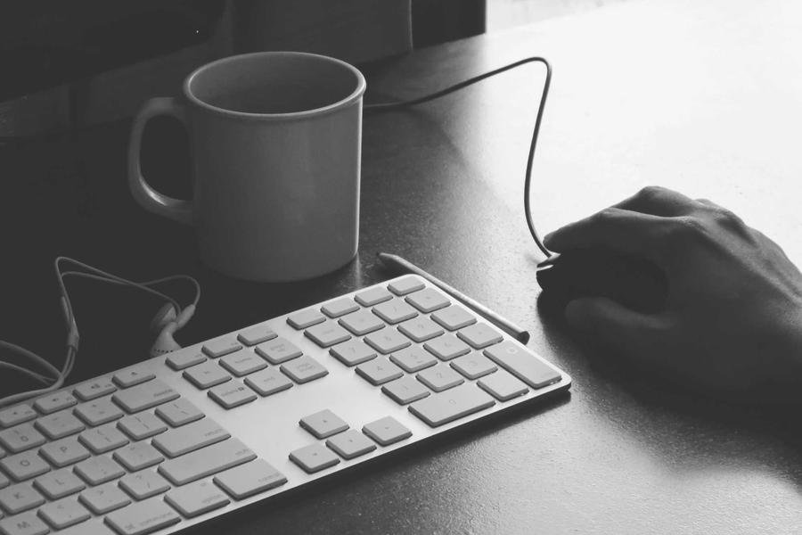 Working on keyboard with coffee mug | Techyza WordPress Development Agency